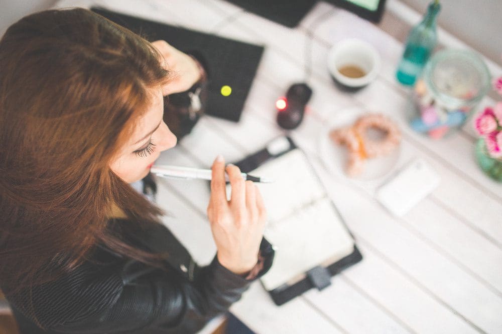 Overhead view of woman with red hair writing out a schedule