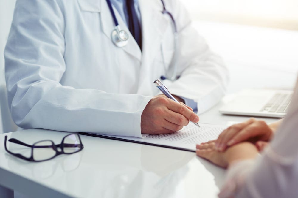 Male doctor and female patient talking at consultation.