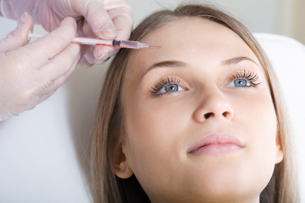 Woman gettting Botox injections in her forehead.