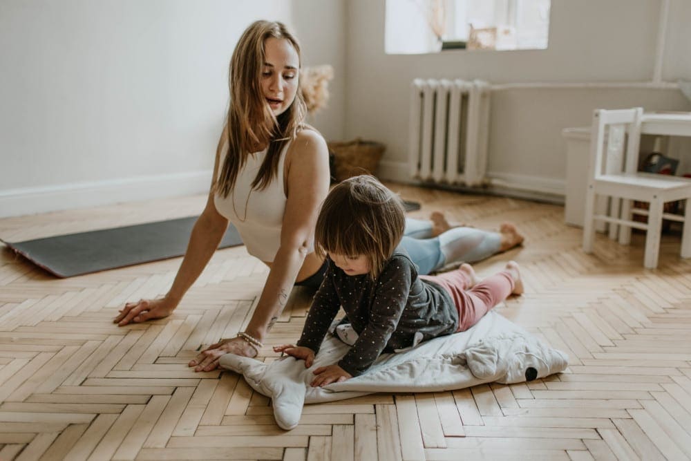 Tummy tuck advice concept. Woman doing yoga with her daughter to get fit for her tummy tuck
