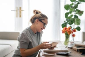 Woman talking on the phone in her home office preparing for her breast augmentation.