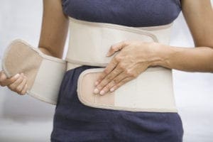 woman's wrapping her midsection with a compression garment.